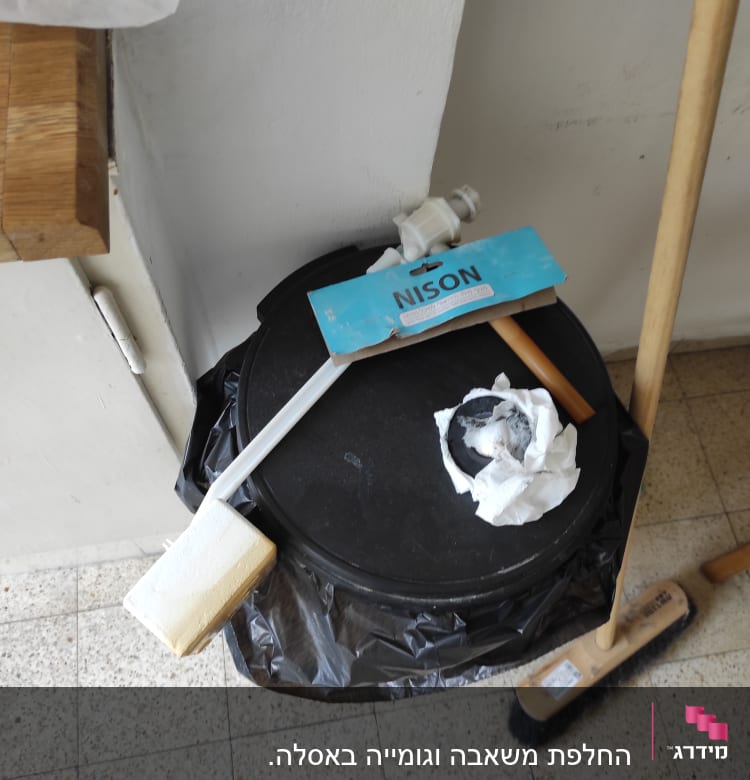 חלקי צנרת וכלי עבודה על פח אשפה